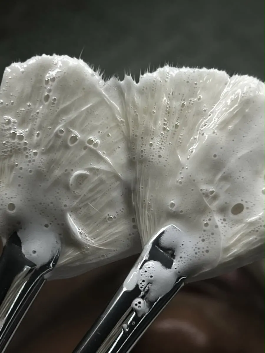 A foaming cleanser applied with fan brushes during a Skin9 Studio facial